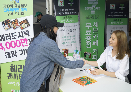 세븐일레븐은 지난 10일 서울 여의도 한강공원에서 열린 '제13회 국방일보 전우마라톤 대회'에 참가해 물품을 후원했다. 이날 대회에서는 세븐일레븐 도시락 모델인 그룹 가수 '걸스데이'의 혜리 씨의 팬사인회도 진행됐다. 팬사인회에서 혜리 씨가 한 팬과 악수를 나누고 있다. <세븐일레븐 제공>